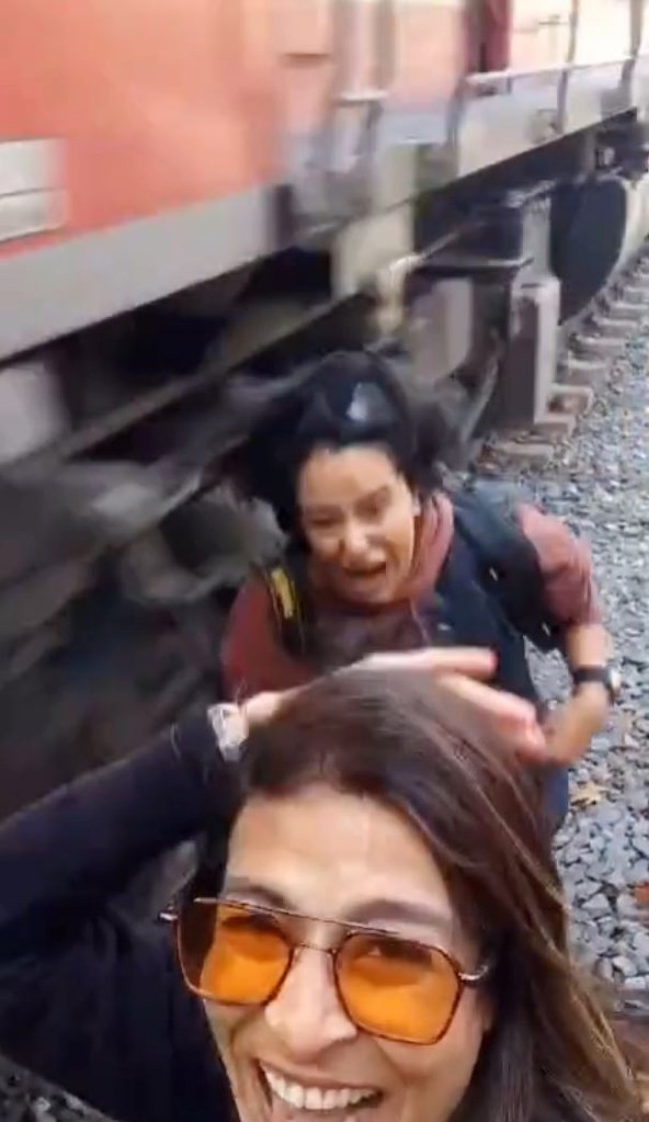 女子在距离被迎面而来的火车撞到的铁轨几英寸处摆姿势自拍