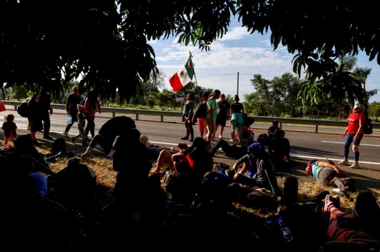 移民大篷车成员在前往埃尔帕索的途中紧紧抓住野兽火车